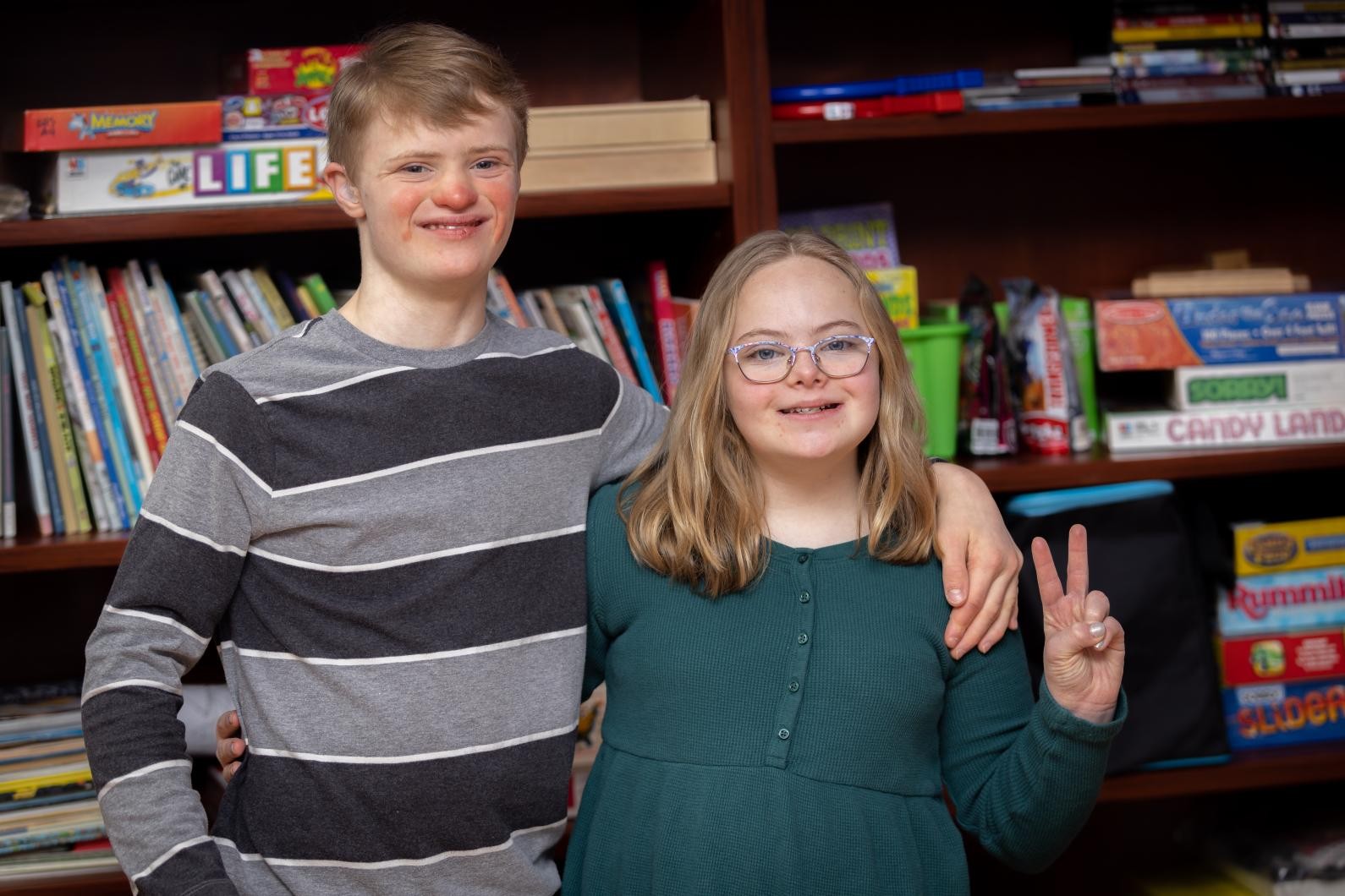A boy and girl pose for a picture with their arms around each other.
